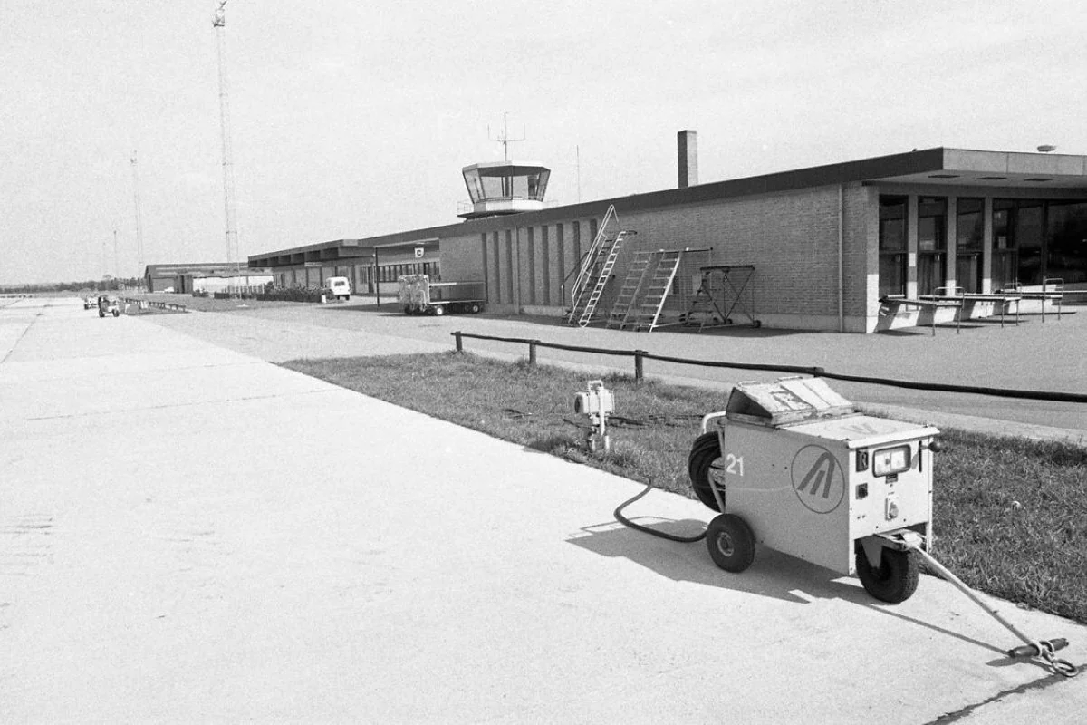 <b>Billund 1975: Der investeres i dansk flytrafik.</b> Der er i løbet af de sidste ti år i alt investeret 37 millioner kroner i Billund Lufthavn. For disse penge har kommunerne fået en gældfri og helt igennem moderne lufthavn, men der skal fortsat i de kommende år investeres en del i sikkerheden. Billunds lufthavn (Billund Airport) blev anlagt i 1961, da Lego-direktør Godtfred Kirk Christiansen etablerede 800 meter lang privat landingsbane og flyhangar nord for LEGO-fabrikken i Billund. Med Godtfred Kirk Christiansen som en afgørende drivkraft blev flere nabokommuner indlemmet i ejerkredsen og lufthavnen planlagt udvidet til en regulær offentlig lufthavn. Den er Danmarks næststørste lufthavn efter Københavns Lufthavn. (Foto: Vejle Stadsarkiv)
