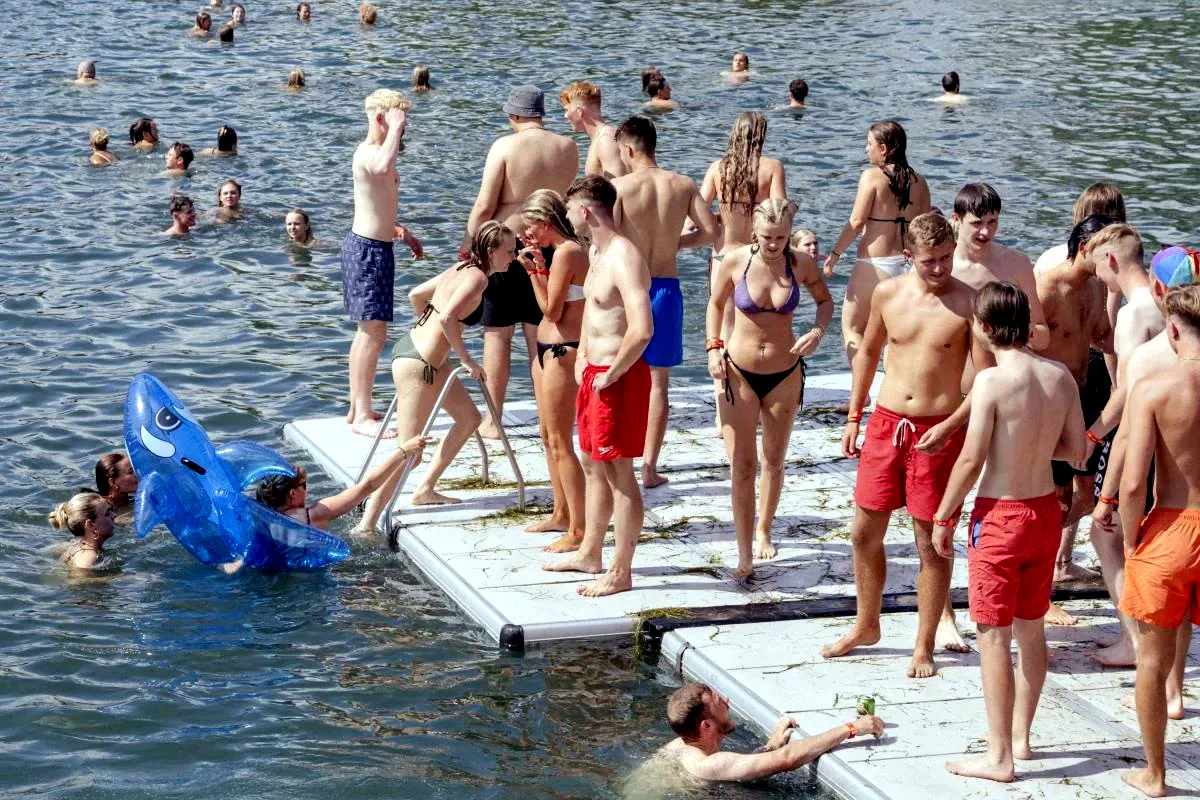 Unge nøgne piger og drenge bader i søen. Roskilde Festival er også kendt for sine legendariske nøgenløb. (Foto: Roskilde Festival)