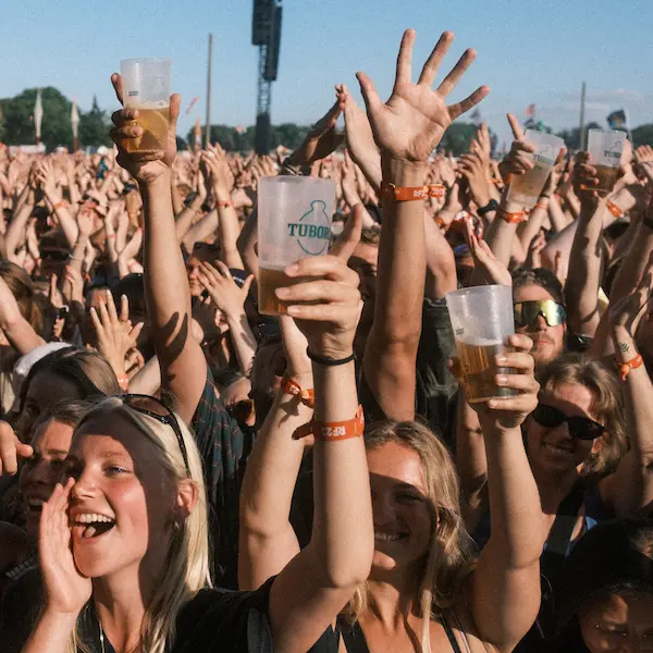Glade unge mennesker med hver deres fadøl til en 50'er. Roskilde Festival løber i år af stablen 29. juni til 6. juli 2024 (Foto: Flemming Bo Jensen/Roskilde Festival)
