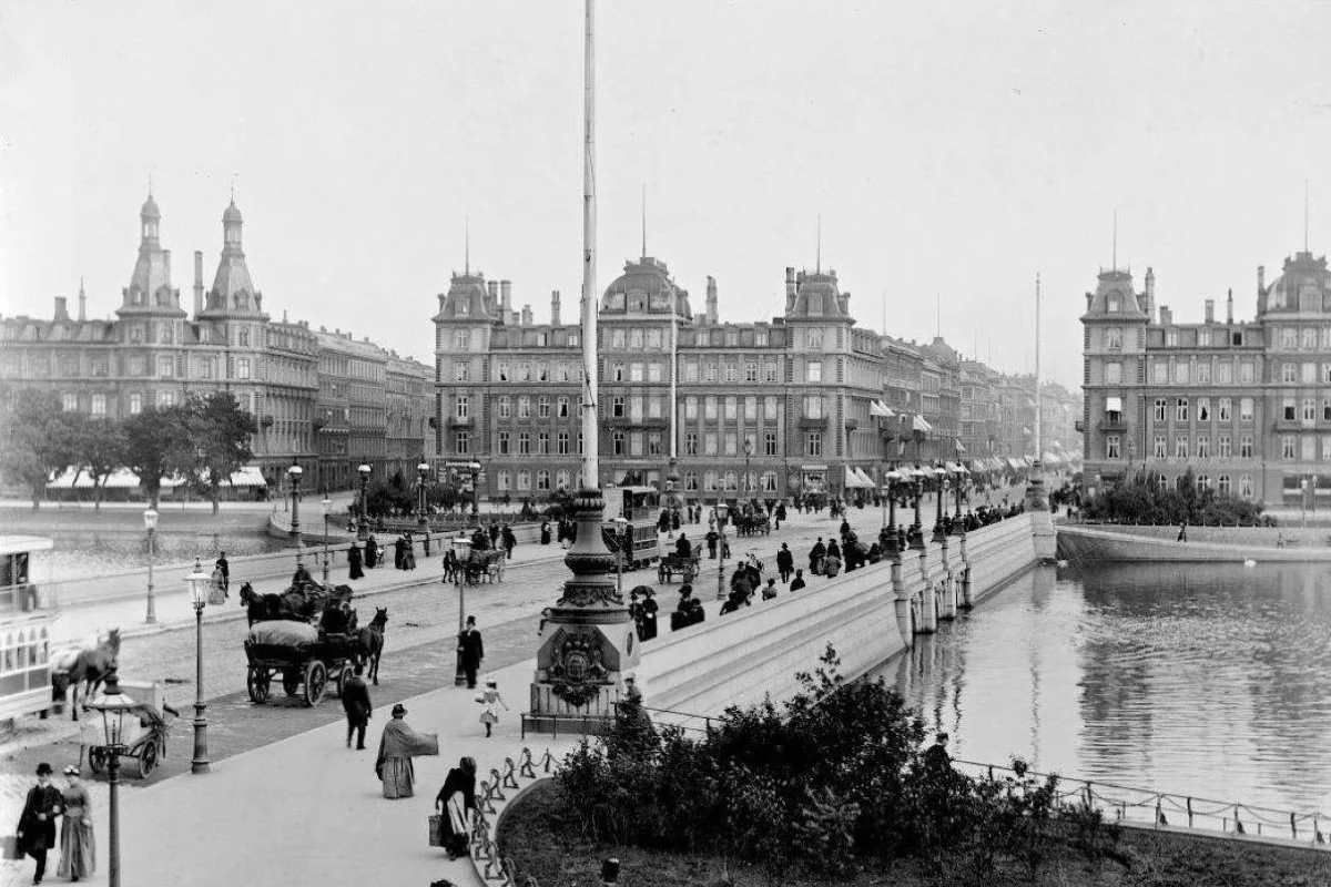 <b>Nørrebro 1928: Københavnerliv - søpromenade.</b> Byens hjerte mellem Nørrebro og Indre By bindes sammen af Dronning Louises Bro. Her en smuk dag, hvor byens borgere promenerer - det ser ud til at have holdt tørt. Billedet er taget fra Nørrebrosiden. (Foto: Københavns Museum)