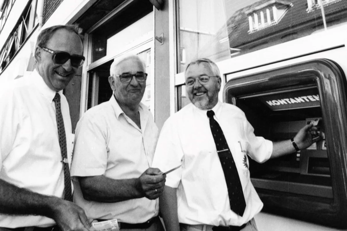 Nordjylland 1980'erne: Indvielse af kontantautomat. Hos Sparekassen Nordjylland på Storegade i Hadsund kunne man indvie en ny kontantautomat, hvor deres kunder nu kan hæve penge, uden at skulle ind og betjenes i banken. Indvielsen blev foretaget af - fra venstre - Poul Skalborg, Svend Åge Bach og Karl Christensen. (Foto: Hadsund Lokalhistoriske Arkiv)