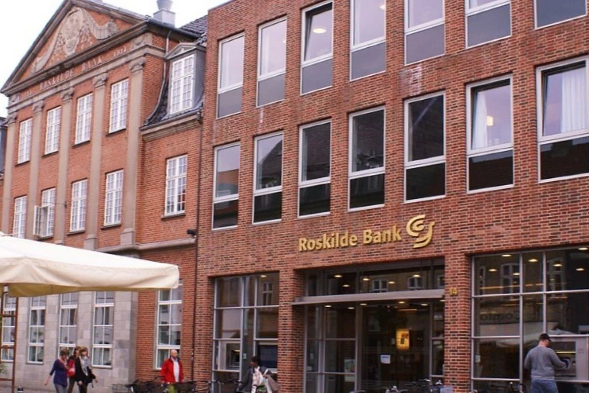 <b>Sjælland 2008: Finanskrise. Roskilde Bank krakker.</b> Krisen kradser. Natten til fredag den 11. juli 2008 meddeler Roskilde Bank, at Nationalbanken har stillet en likviditetsgaranti til rådighed, og at banken er sat til salg. Det lykkes ikke at sælge banken, og den 24. august overtager Nationalbanken og Det private beredskab banken. Her billede af bankens hovedkontor på Algade 14 i Roskilde. (Foto: Mogens Engelund/WikiMedia, Creative Commons)